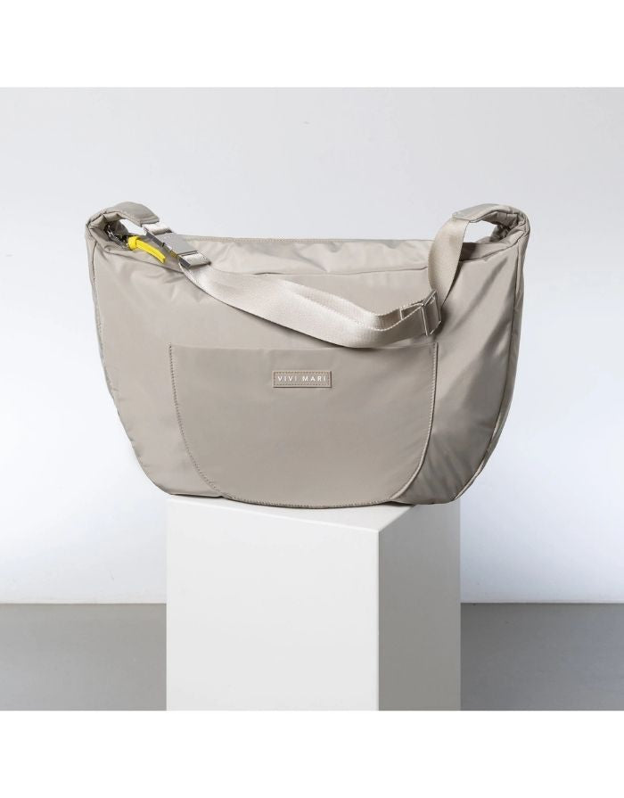 Padded Hip Bag Oversized von Vivi Mari in Stone, große wasserabweisende Umhängetasche mit zwei Außentaschen, verstellbarem Schultergurt und silbernen Metallakzenten, aus recyceltem Polyester.