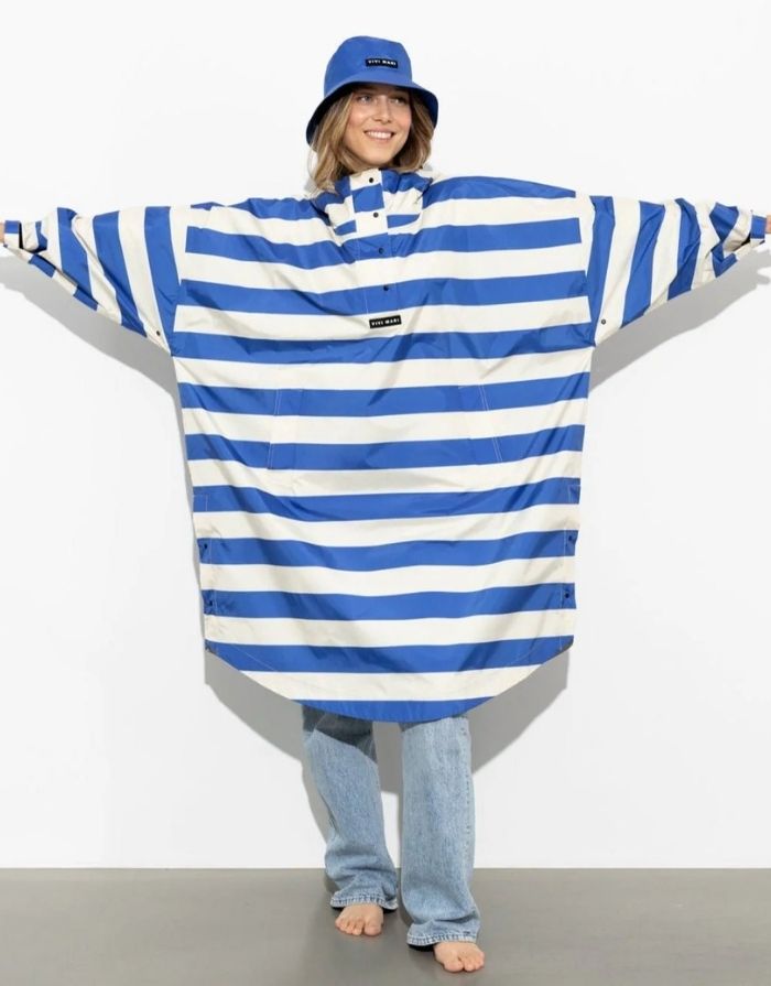 Raincoat Bold Stripes Blue/Sand von VIVI MARI – wasserdichtes Cape aus recyceltem Polyester in Oversize-Passform mit Kapuze, Klettverschluss-Manschetten und seitlichen Taschen, nachhaltig und funktional für Stadt, Fahrrad und Alltag