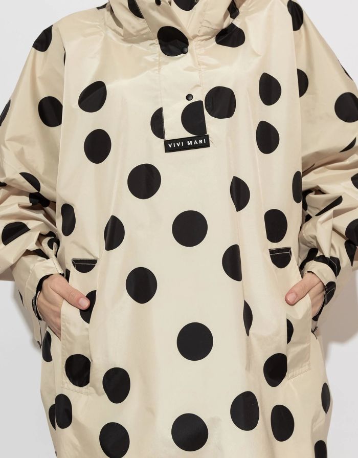 Raincoat Bold Stripes Dots Black/Sand von VIVI MARI: Langer, wasserdichter Regenmantel im Streifen-Design, oversized geschnitten mit Kapuze, Knopfleiste, Klettverschluss-Manschetten und praktischen Taschen – nachhaltig aus recyceltem Polyester gefertigt.