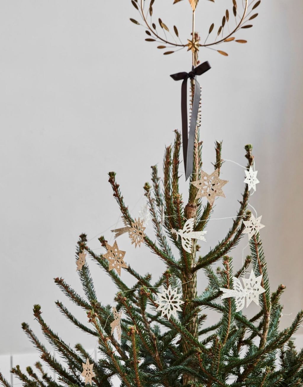 Champagnerfarbene Girlande Figure von House Doctor aus Papier mit verschiedenen Figuren und goldenen Glitzerdetails am Weihnachtsbaum